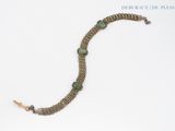 bracelet with green glass beads and silver chain on a white background
