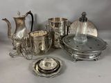 a silver tea set on a table next to other silver items