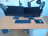 two computer monitors and a keyboard on a desk