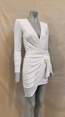 the mannequin is wearing a white dress with long sleeves