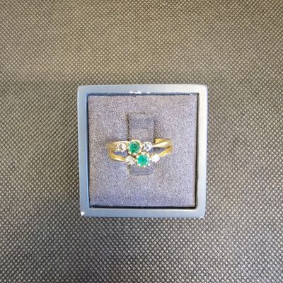 une image représentant une bague en or sertie d'une pierre verte et blanche