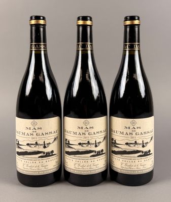 trois bouteilles de vin posées sur une table l'une à côté de l'autre