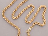 un collier à chaîne dorée avec un fermoir, sur fond gris