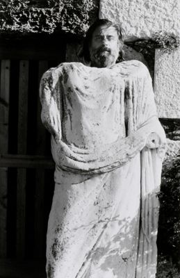 photographie en noir et blanc d'une statue de Jésus se dressant devant un bâtiment