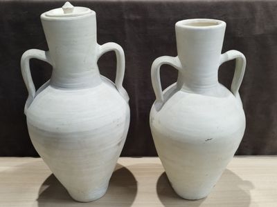 two white vases that are sitting on a table