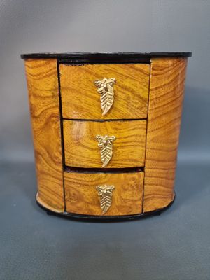 an image of a small wooden box with three drawers on it