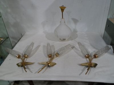 four glass vases and a gold vase on a white table