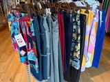 clothes hanging on a clothes rack in a clothing store