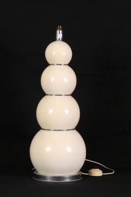 une lampe de table blanche surmontée de trois boules