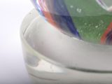 a glass bowl with a colorful marble inside of it