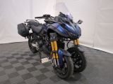 une moto qui est garée dans une pièce dont le sol est en damier