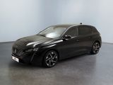 La voiture noire est garée dans une grande pièce aux murs blancs.