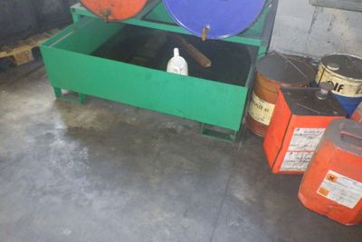 de nombreux fûts et bidons dans une pièce au sol en béton