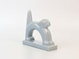 a gray cat figurine on a white surface