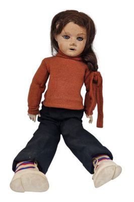 a small doll that is sitting on the ground