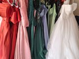 un grand nombre de robes suspendues à une étagère dans une pièce