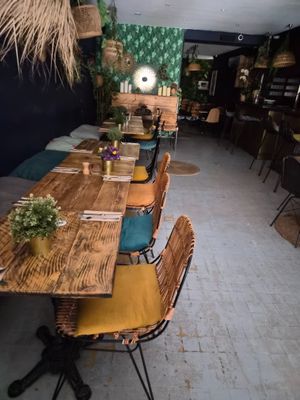 une longue table entourée de nombreuses chaises et tables dans la pièce