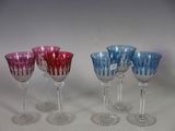 four wine glasses are lined up in a row on a table
