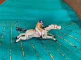 a figurine of a man riding a horse on a green blanket
