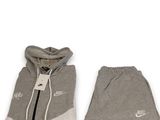 Ensemble composé d'un sweat à capuche gris et d'un pantalon de survêtement, avec le logo Nike sur le côté