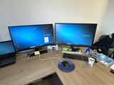 a desk with three monitors and a laptop on it