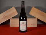 a bottle of wine sitting on a table next to two wooden boxes