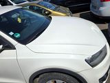 a white car parked in a parking lot with other cars in the background
