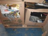 a cardboard box full of clothes and a pair of scissors