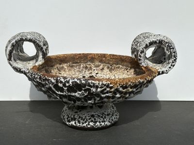 a black and white bowl with two handles on a table