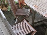 a wooden table and four chairs on a wooden deck