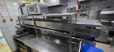 plan de travail en acier inoxydable dans une cuisine professionnelle équipée de fours à micro-ondes et d'autres appareils électroménagers
