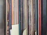 beaucoup de disques vinyles dans une boîte posée sur la table
