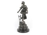 statue of a woman sitting on a chair with a basket of flowers
