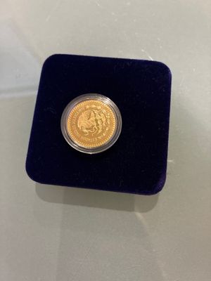 a gold coin in a velvet case on a table