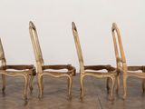 four chairs are lined up in a row on a wooden floor