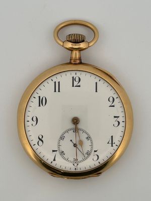 a close up of a gold pocket watch on a white surface