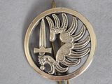 une image représentant un pendentif en or et en argent orné d'un oiseau