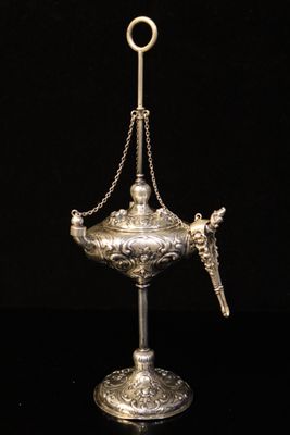an antique silver plated incense holder with a chain around it