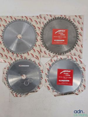 trois lames de scie circulaire sont posées sur une feuille de papier