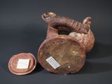 a brown vase with a tag on it next to a coin