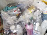 a pile of cleaning supplies in plastic bags on the floor
