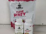 un sachet de whey transparent à côté de deux bouteilles de whey