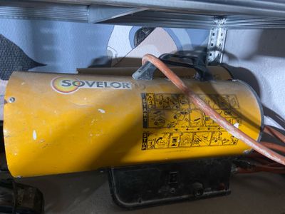 a yellow gas can with wires attached to it