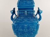 une image représentant un vase bleu posé sur une table blanche