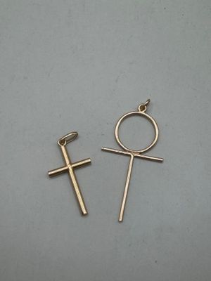a pair of cross earrings on a gray surface