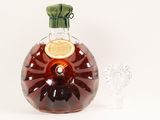 a bottle of brandy next to a glass on a table