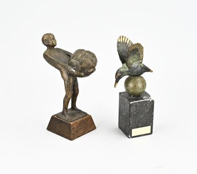 pair of bronze sculptures of a boy and a bird on a marble base