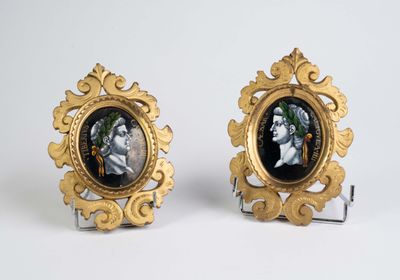 une paire de cadres photo dorés et noirs sur lesquels figurent un homme et une femme