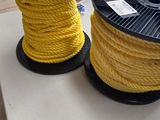 deux bobines de corde jaune posées sur une table dans une pièce