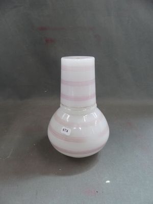 a small white vase with a pink stripe on it